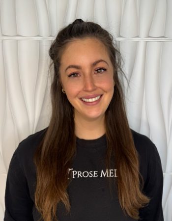 a person smiling in front of a curtain